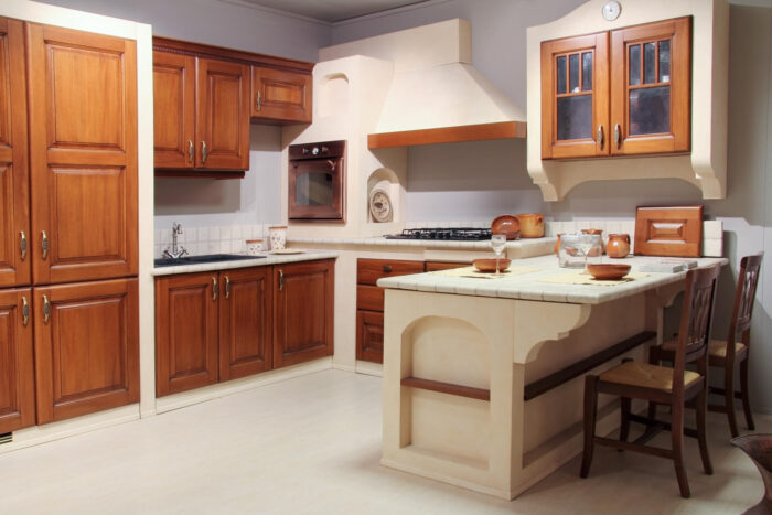 Full view of a classic wooden and stone kitchen with complete furniture.