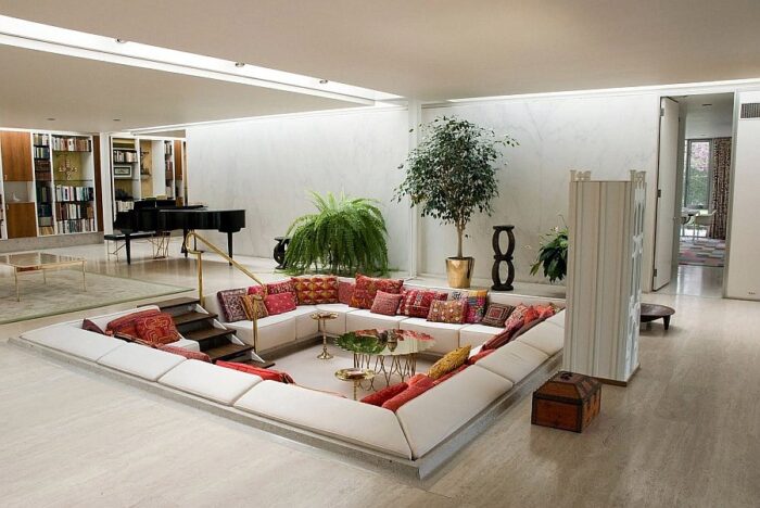 A sunken living room with couches and a piano.