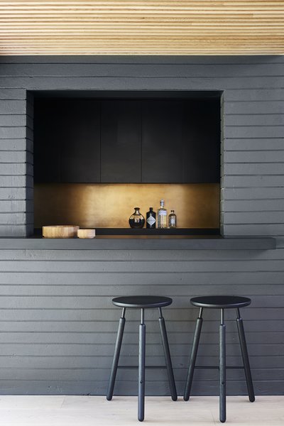 A kitchen with black counter and stools, perfect for living room bar ideas.