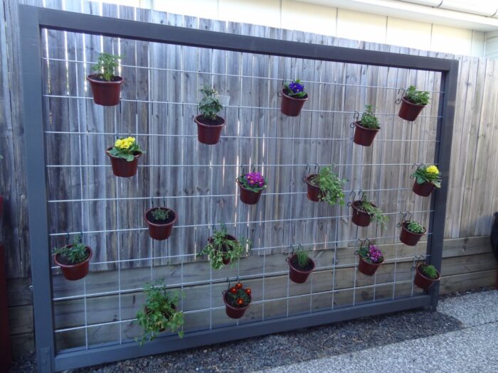 A wooden fence with a Hanging Garden.