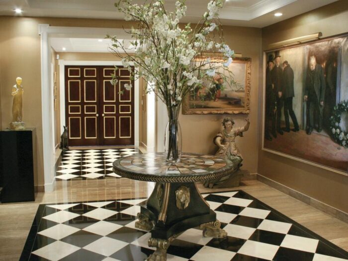 A checkered floor in a foyer featuring an architecturally inspired black and white design.
