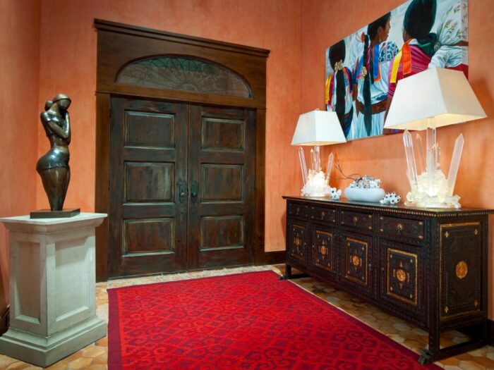 An architecturally designed entryway with a red rug and two lamps.