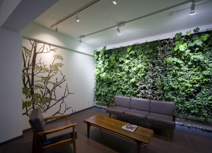A green wall in an office with architectural elements.