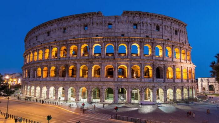 The colossion is lit up at night, showcasing cool architecture in Rome, Italy.