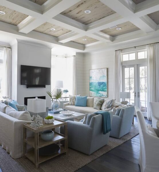 A beach-themed living room with white furniture and blue accents.