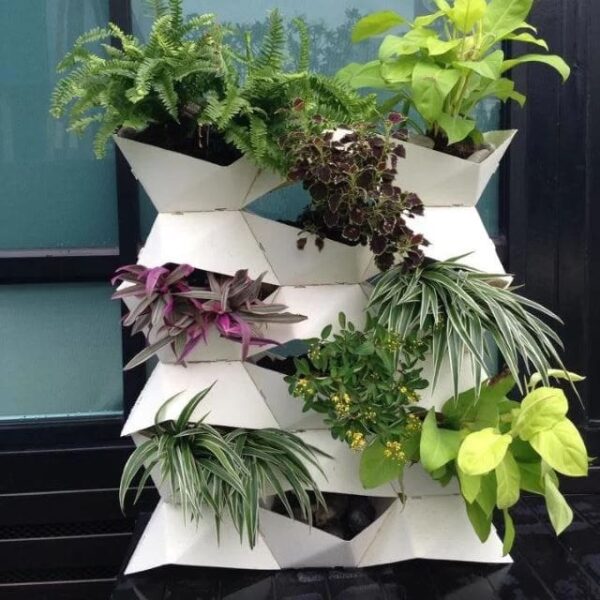 A variety of plants hanging on a white planter.