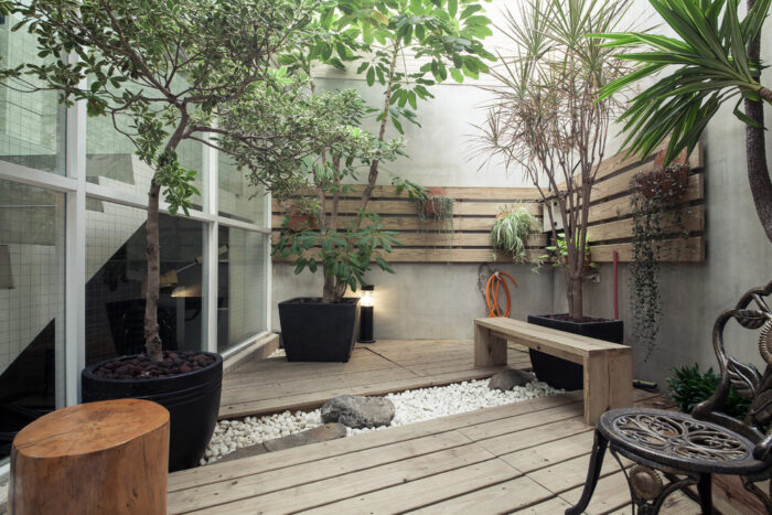 Zen garden ideas featuring a wooden deck with plants and a bench.