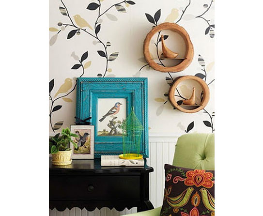 A living room with a green chair and bird-themed wall decor.