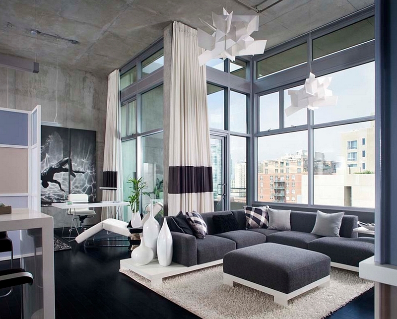 A masculine living room with large windows and a grey couch.