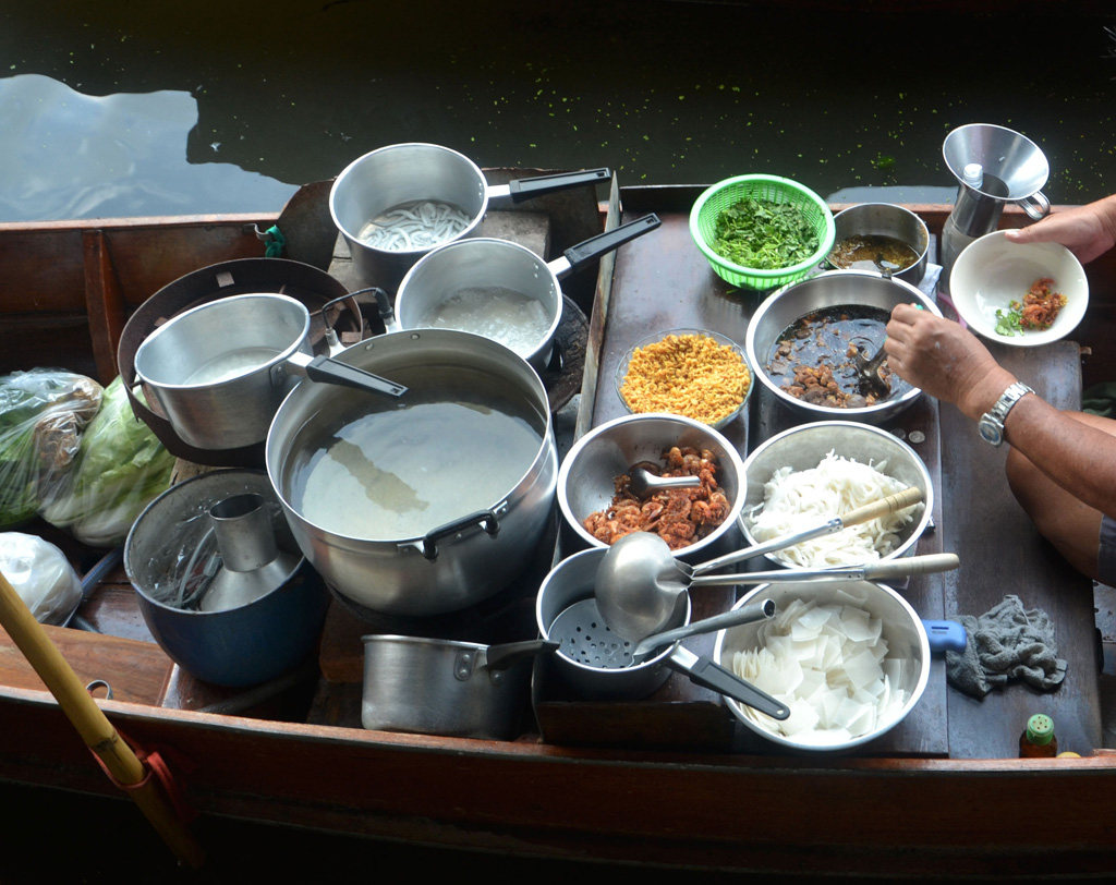 A man cooking in a boat.