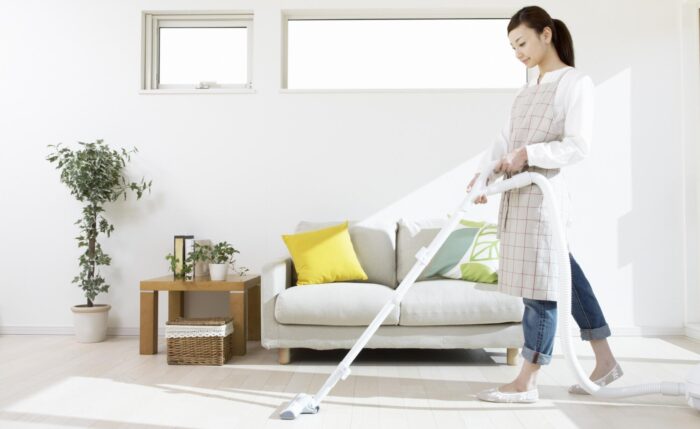 Asian woman disinfecting the living room with a mop.