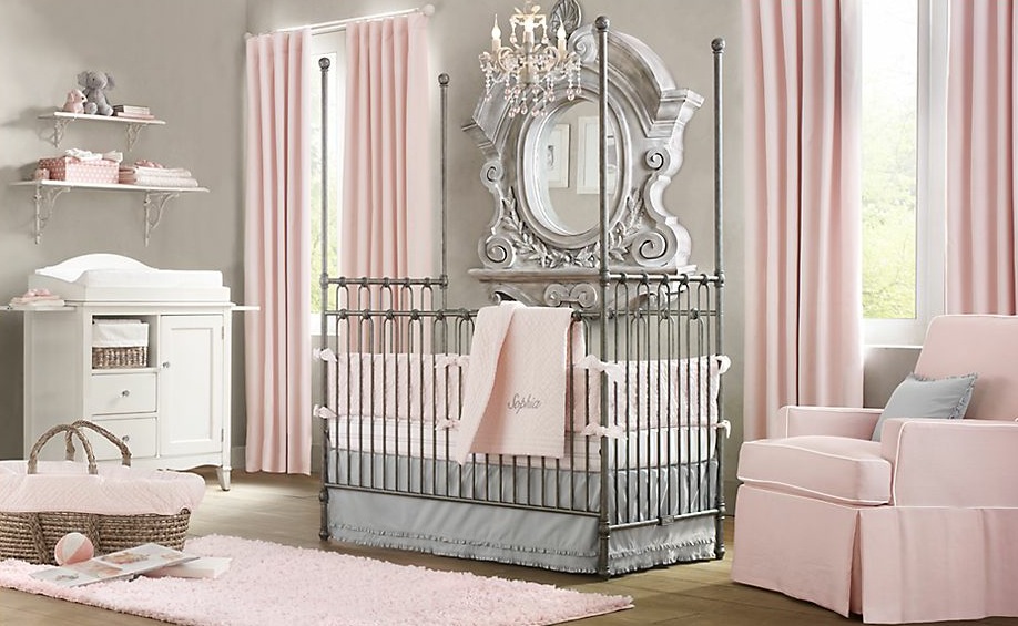 A pink and white baby room with a crib, dresser and mirror for nesting.
