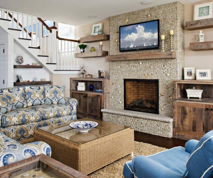 A beach themed living room with blue furniture and a fireplace.