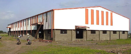 An industrial shed with a white and orange roof.