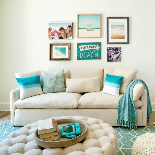 A beach-themed living room with pictures on the wall and a couch.