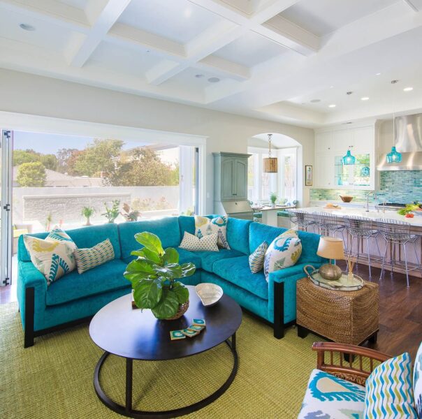 A beach themed living room with a turquoise couch and a coffee table.