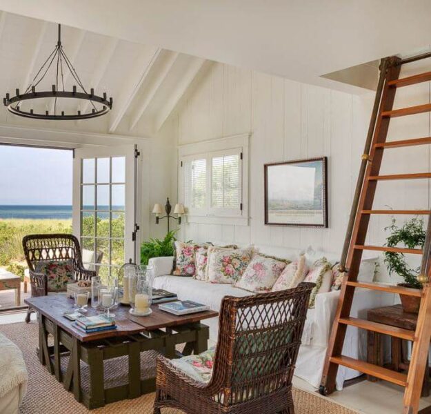 A beach-themed living room featuring wicker furniture and an ocean view ladder.