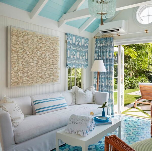 A blue and white beach themed living room with white furniture.