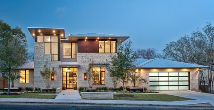 The exterior of a modern home at dusk with ancient architecture styles.