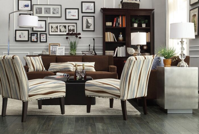 A masculine living room with a brown couch and striped chairs.