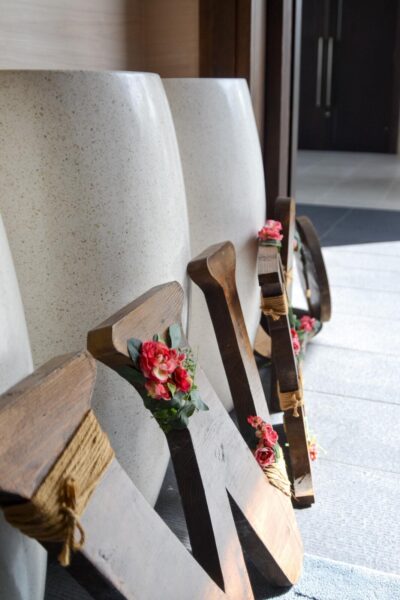 A wooden sign with flowers on it sits in front of a door, adding a touch of decor to the entrance.
