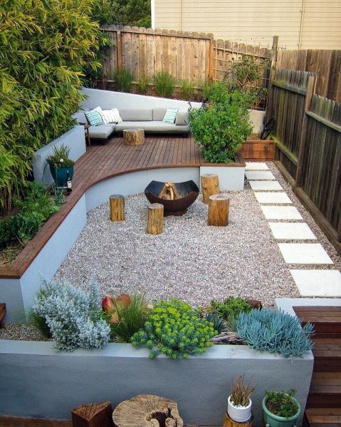 A backyard with a wooden deck and garden ideas.