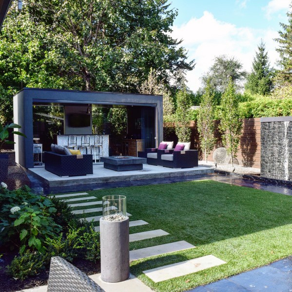 A modern backyard with a waterfall and garden ideas.