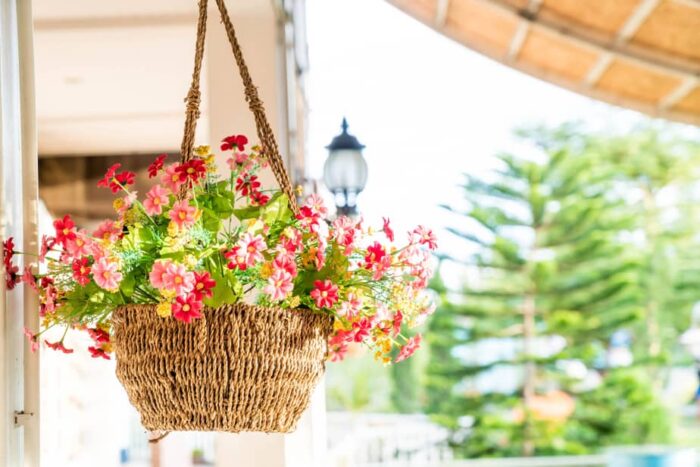 A balcony adorned with a wicker basket of flowers.