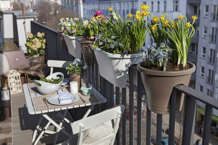 Balcony garden with potted plants and seating.