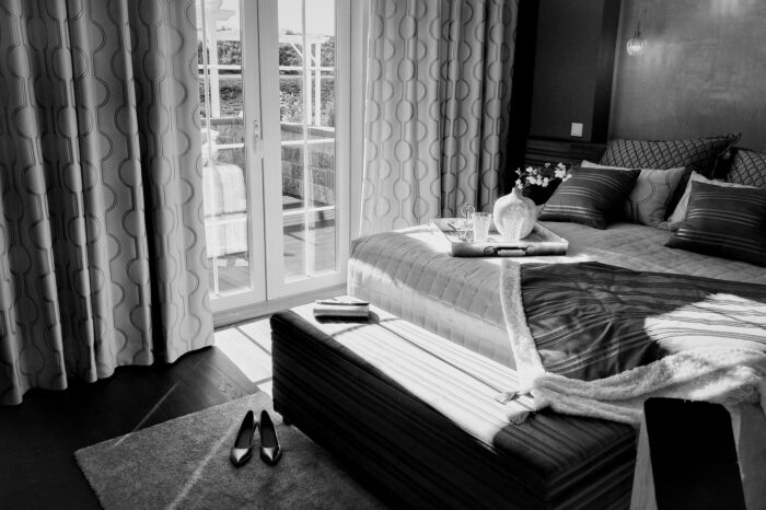 A black and white photo of a bed in a bedroom.