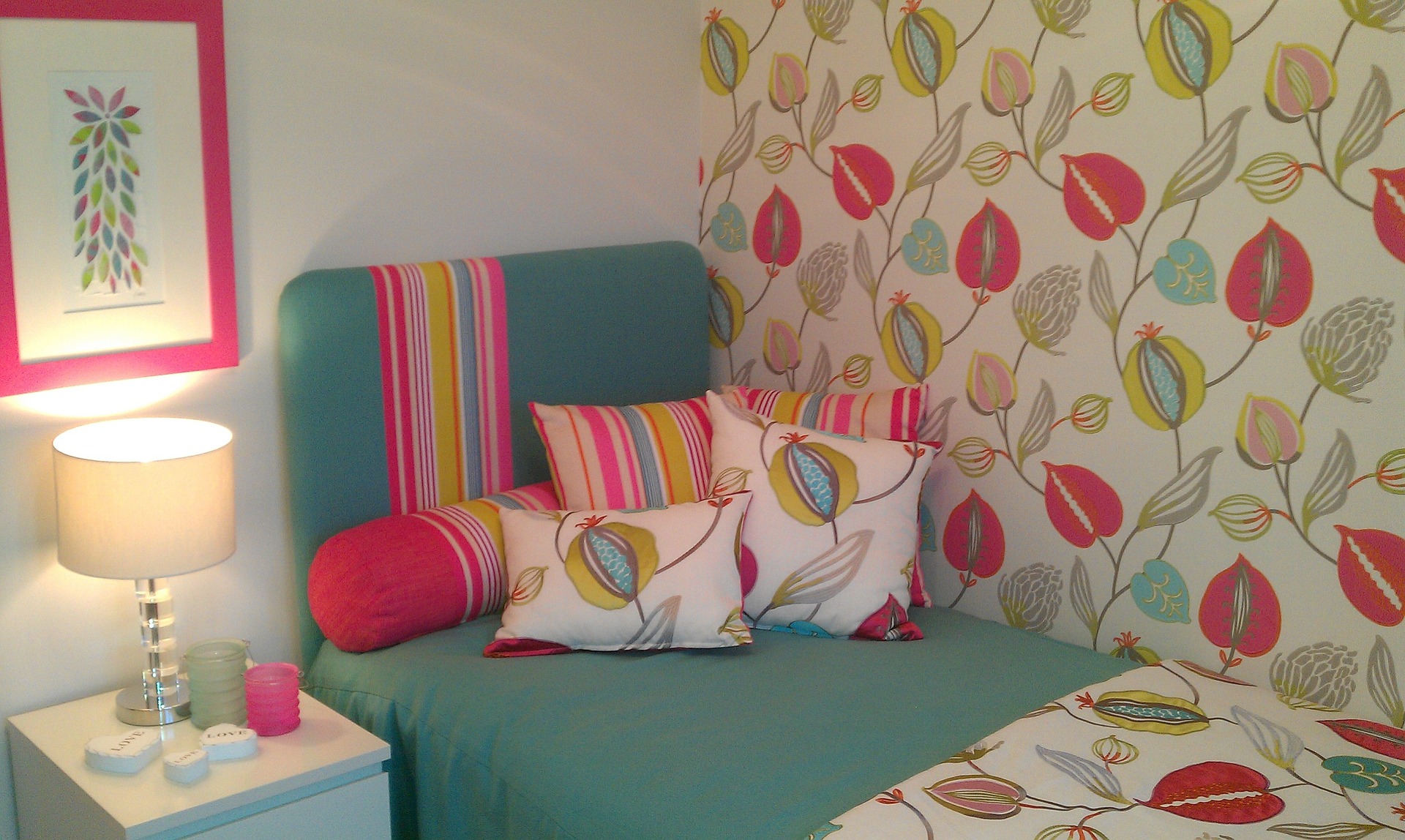 A bed in a room with vibrant wallpaper decor.