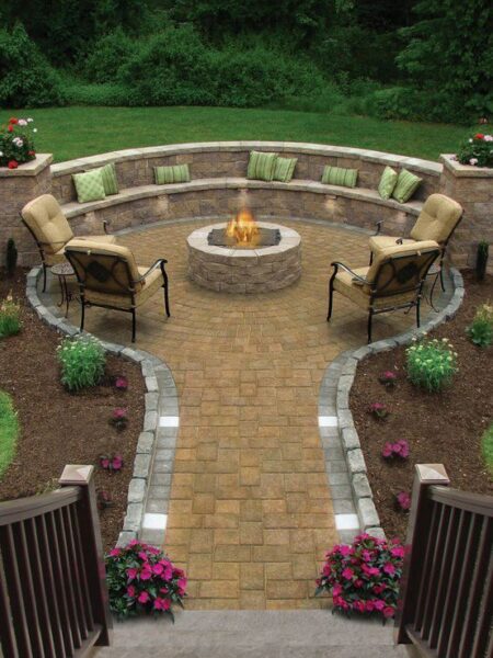 An outdoor living space featuring a circular patio with a fire pit in the middle.
