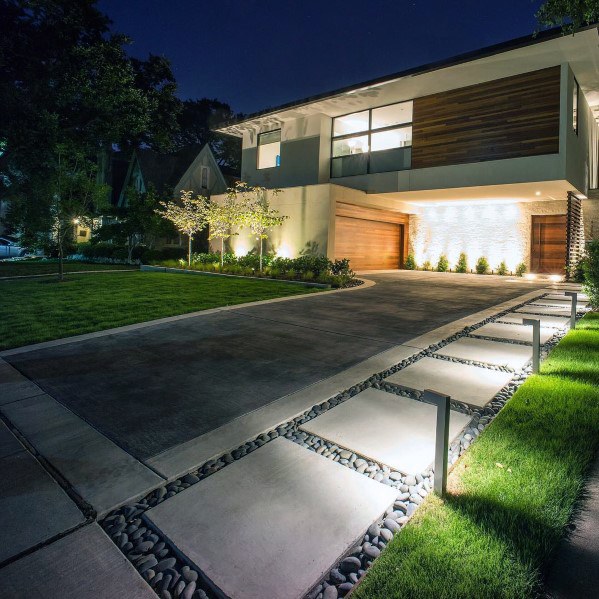 A modern home with garden lighting at night.