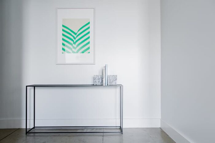 A white console table with a green chevron print, perfect as wall decor.