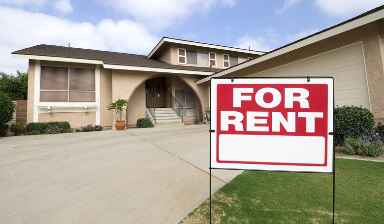 A for rent sign in front of a house, highlighting important factors to consider when renting your first home.