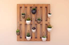 A wooden wall mounted planter with hanging pots, perfect for adding stylish wall decor.