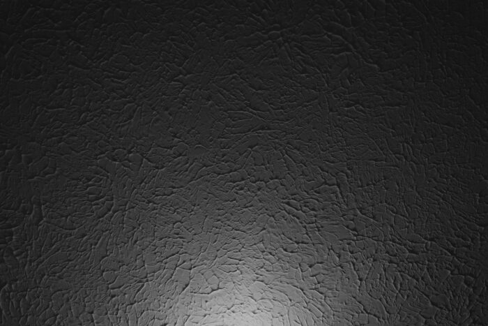 A black wallpaper with a light shining on it.