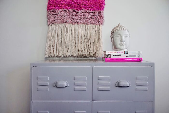 A pink locker with a tassel hanging from it.