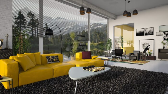 A living room with yellow furniture and a view of mountains.