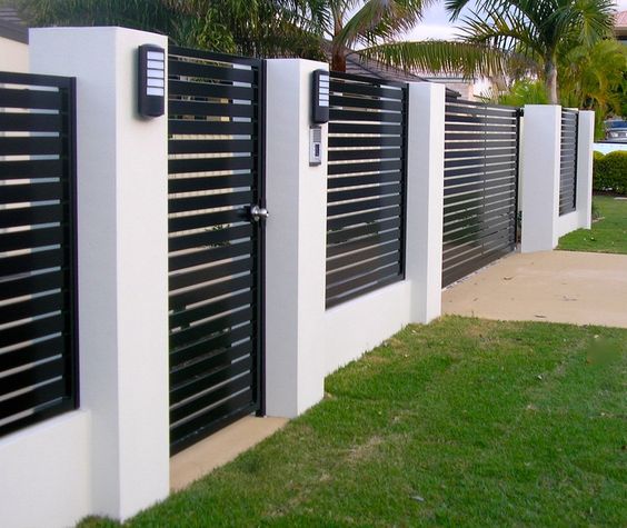 An architecturally designed black and white fence with a black gate.