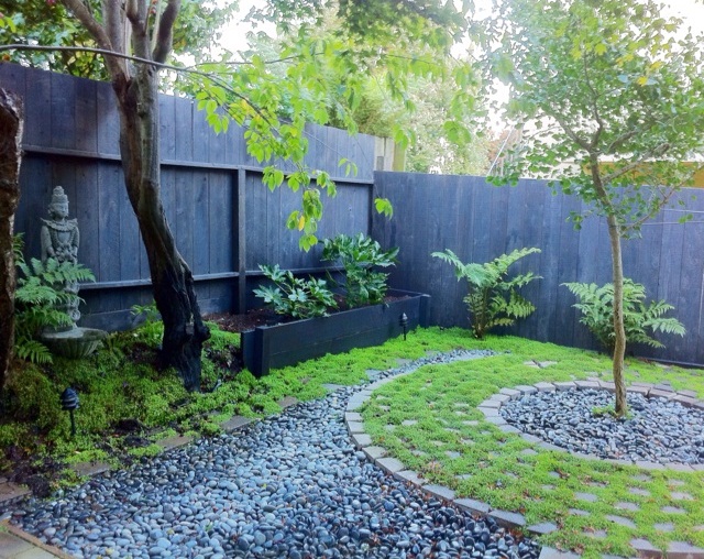 A small Zen garden with a stone garden and a tree.
