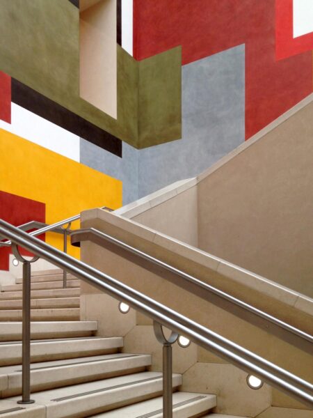 A staircase leading up to a vibrant, colorful wall with unique color schemes.