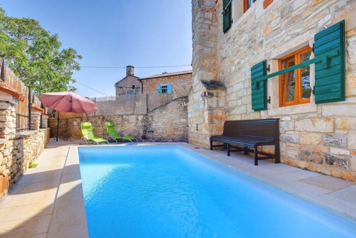 A stone house featuring a swimming pool designed with architectural finesse.