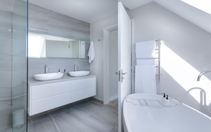 A modern bathroom with a white tub and sink featuring a sleek color scheme.