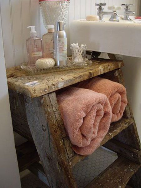 A bathroom with towel storage on a wooden ladder.