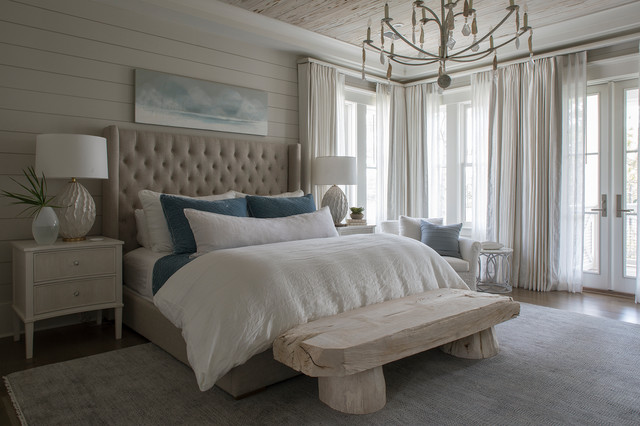A beach-style bedroom with a chandelier.
