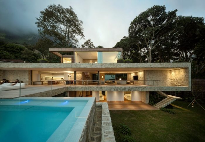 A contemporary house with a swimming pool nestled in the mountains.