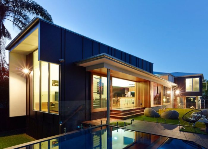 A contemporary house with a swimming pool at dusk.