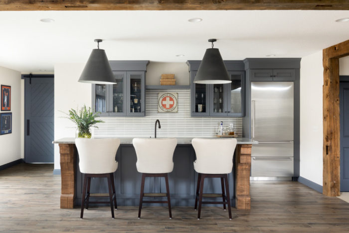 A kitchen with a home bar and wood beams.
