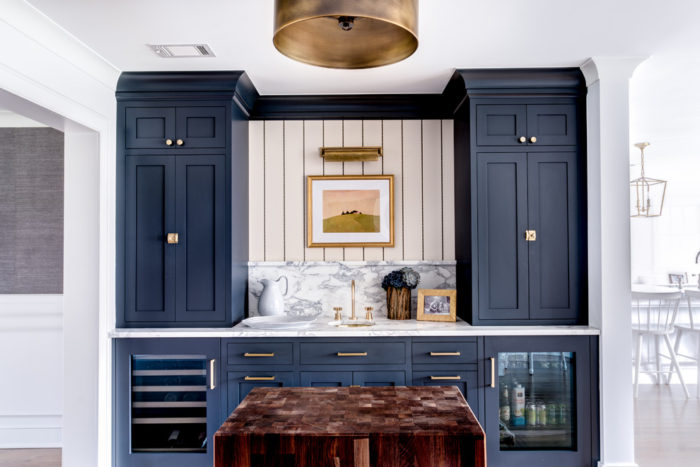 A kitchen with blue cabinets and a marble counter top, perfect for home bar ideas.